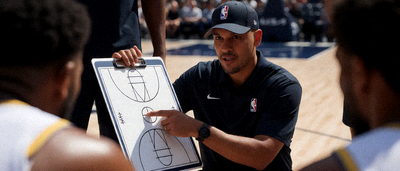 NBA球队主教练在场边指挥比赛，手持战术板向球员讲解战术安排的特写镜头